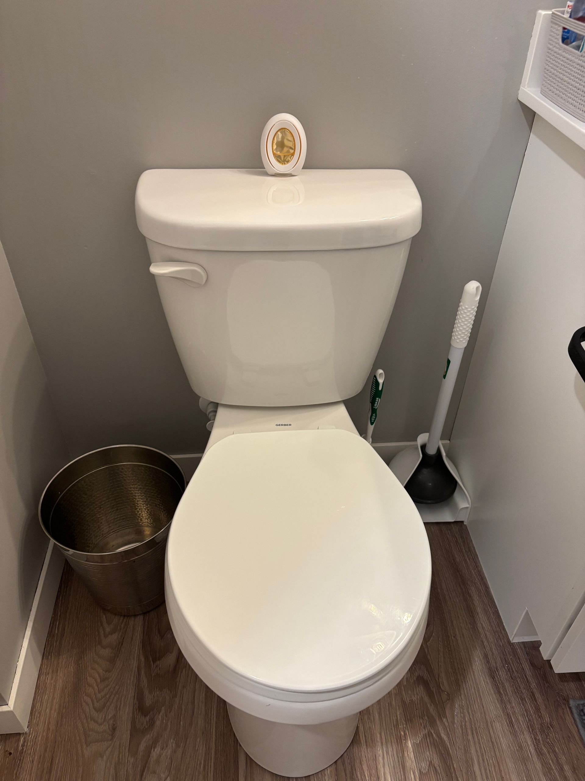 White toilet with open lid in a bathroom with white brick-style tiles and sink.