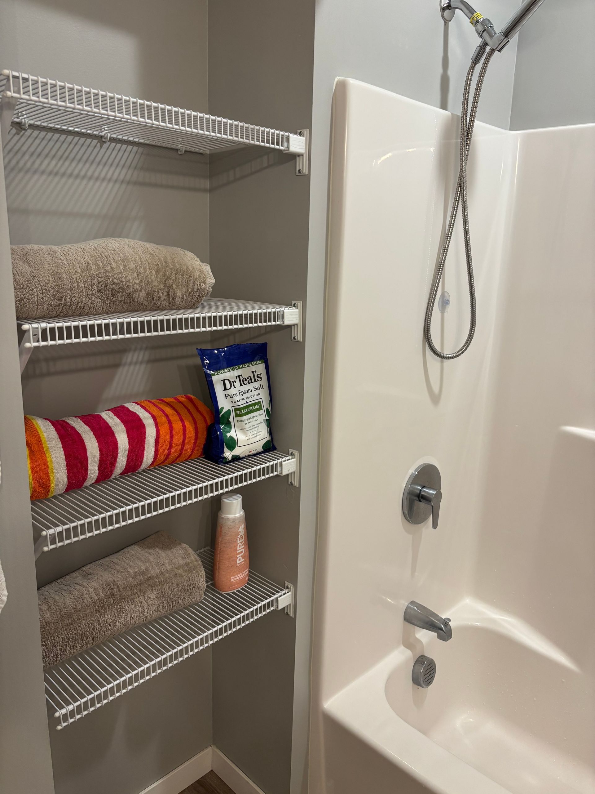 Woman holding a mop and bucket, smiling in a kitchen with a washing machine and blinds.