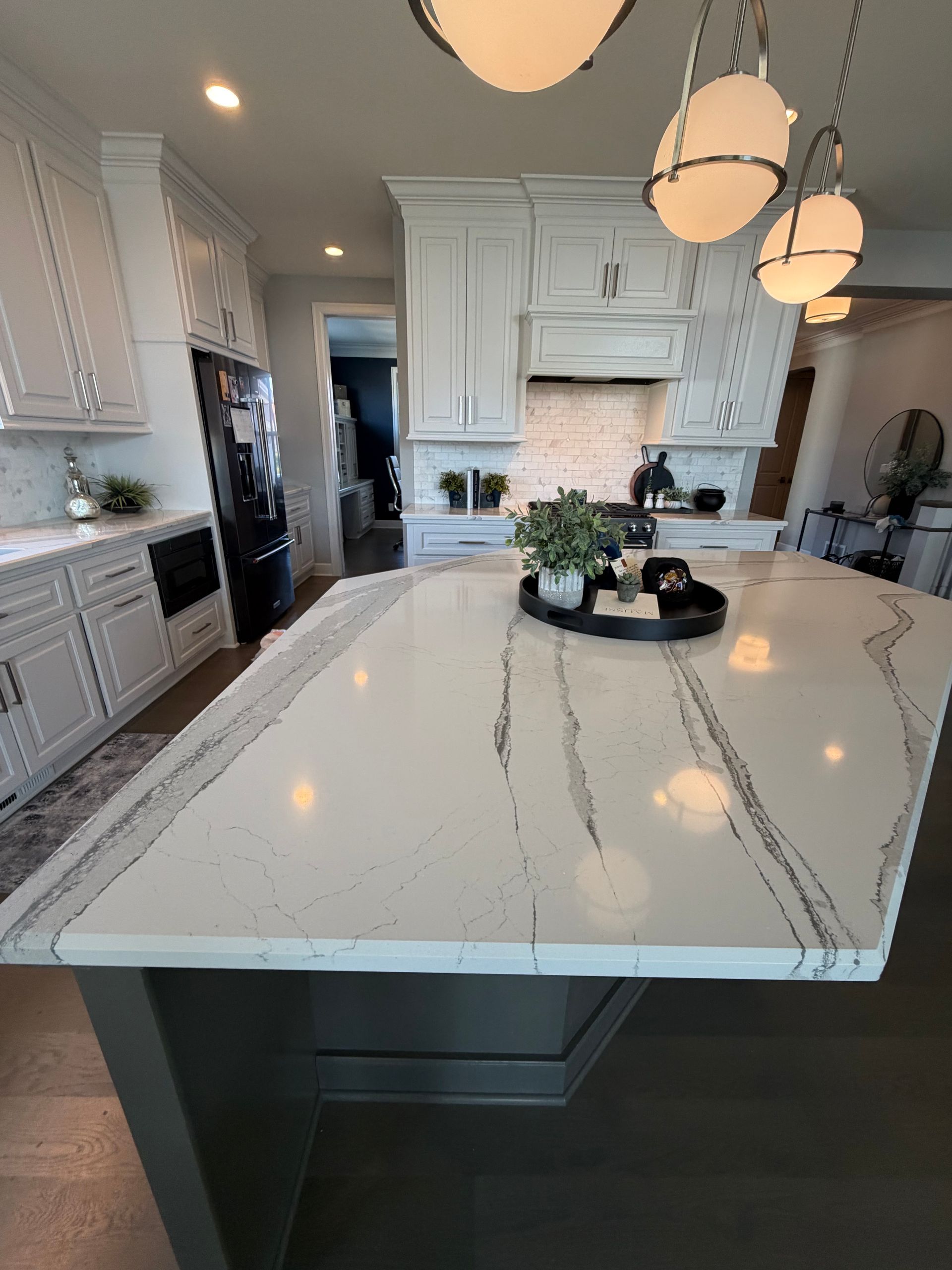 Woman smiling, holding spray bottle and wearing cleaning gloves, standing by glass door.