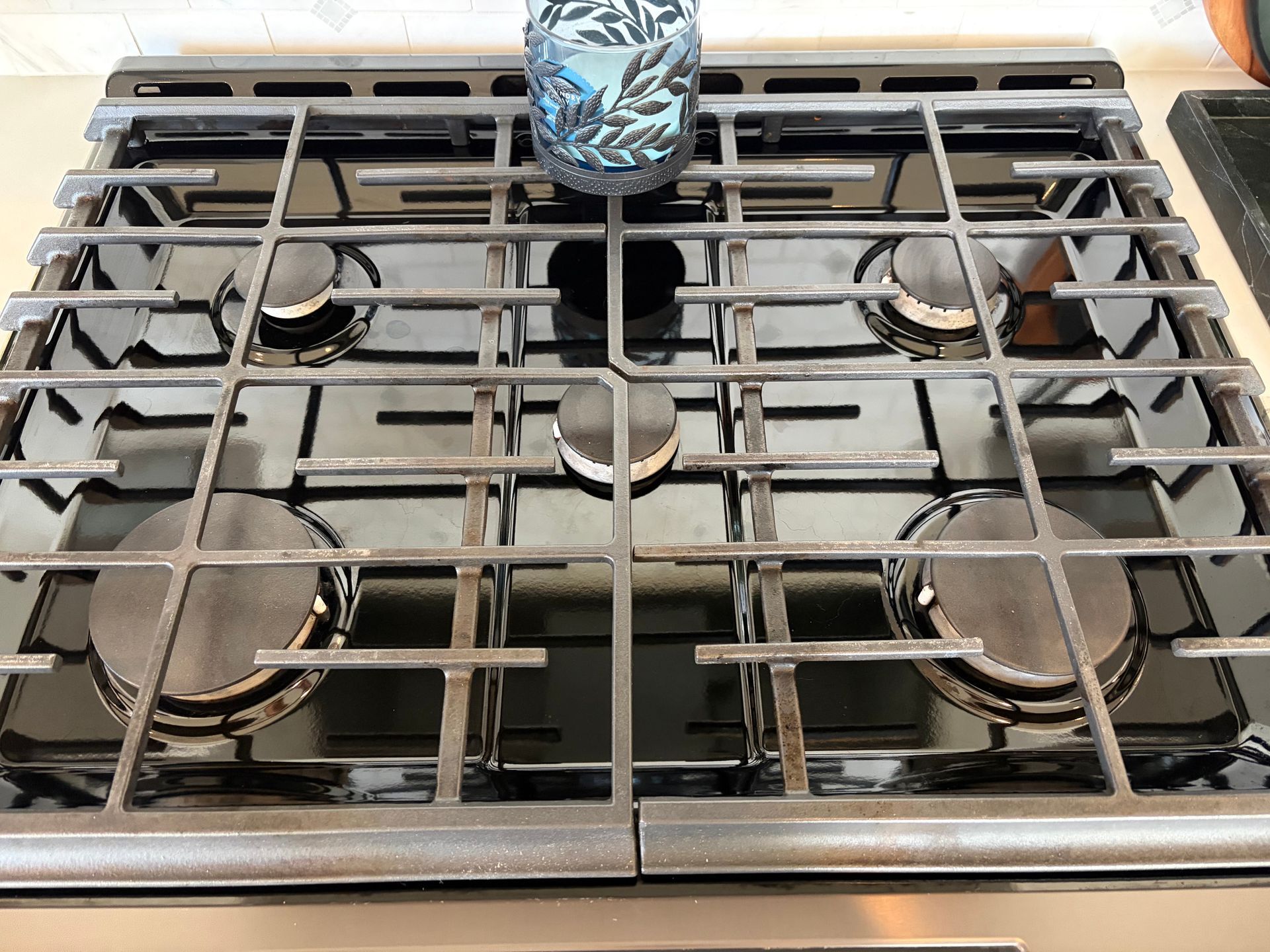 Modern kitchen with white cabinets, stainless steel appliances, and a blue island.
