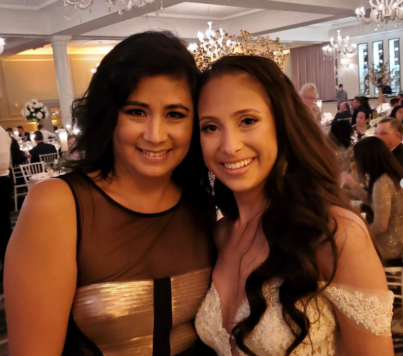 Two women posing for a picture at a wedding reception