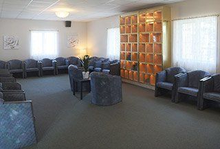 Une grande salle d'attente remplie de chaises et de tables.