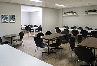 Il y a beaucoup de tables et de chaises dans cette pièce.