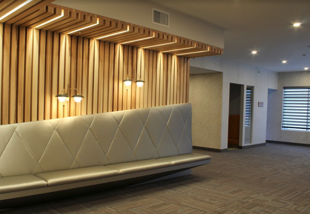 Une salle d'attente avec un banc et un mur en bois