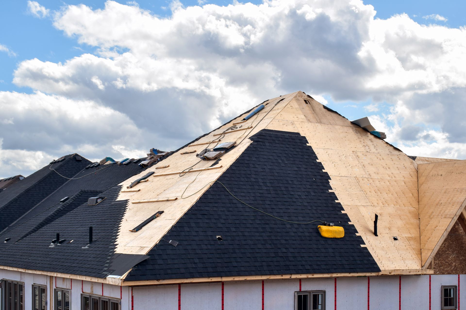 Engineer standing on rooftop looking away and holding blueprint project. Mature construction worker kit standing with copy space. Workman inspecting construction site with sheet of paper in hand.