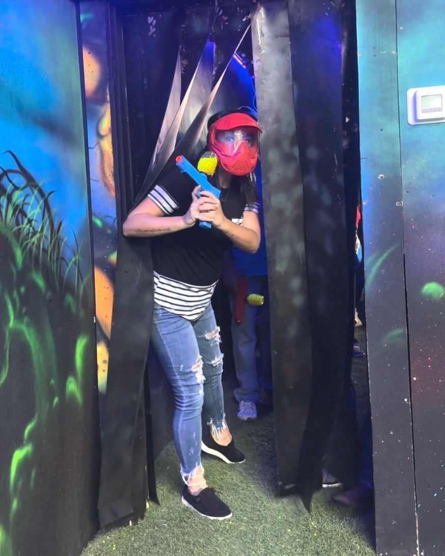 Player in a red mask stepping out of cover with a toy blaster in hand.