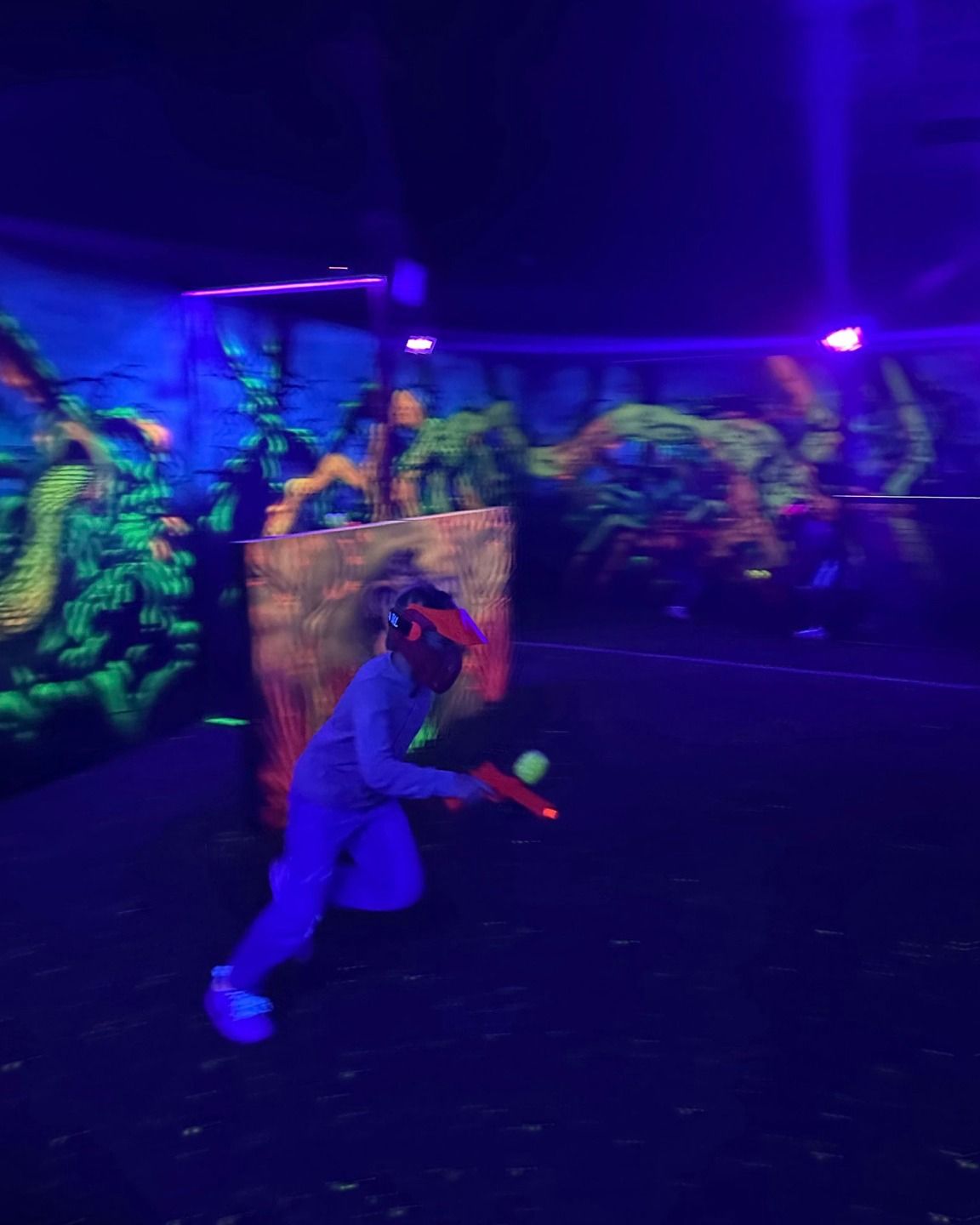 A person is playing a game of glow in the dark paintball.