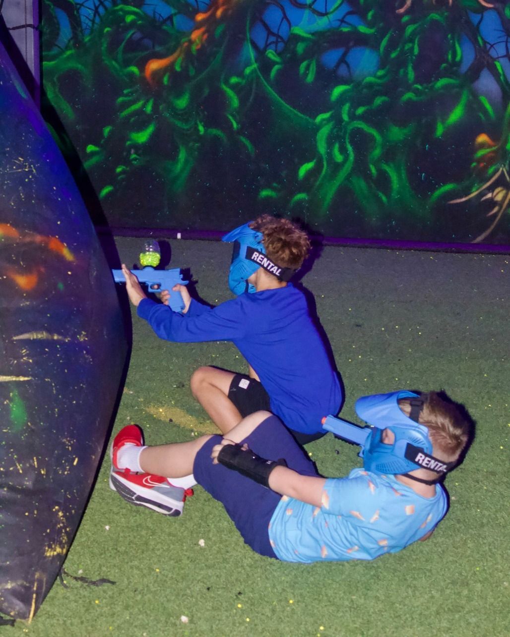 Two boys wearing masks are playing a game of laser tag