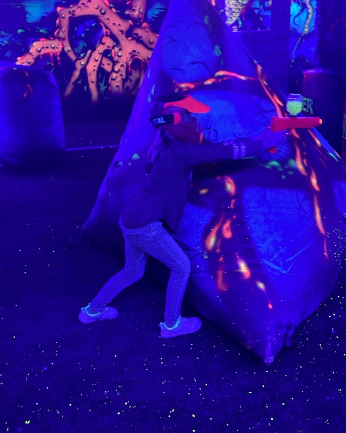 A person is standing in front of a glow in the dark room.