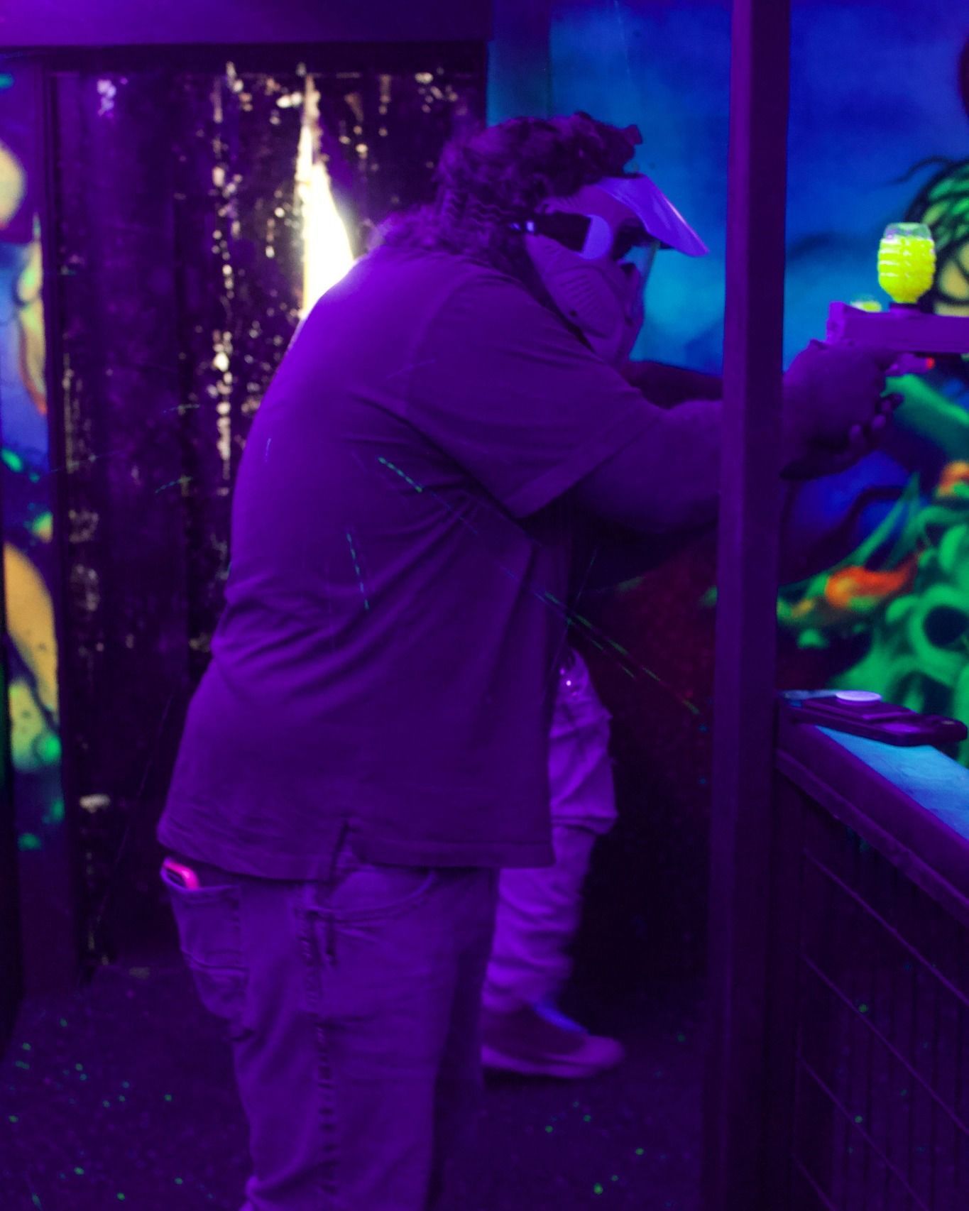 A man in a purple shirt is standing in front of an aquarium