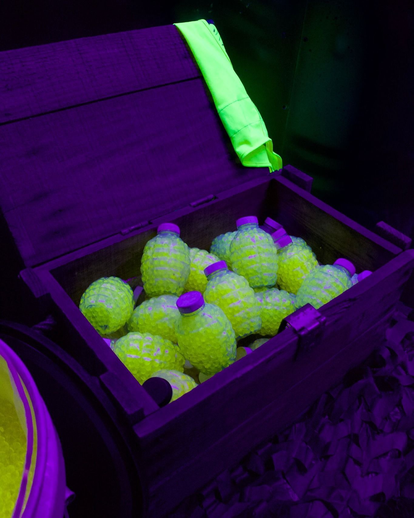 A wooden box filled with glow in the dark tennis balls.