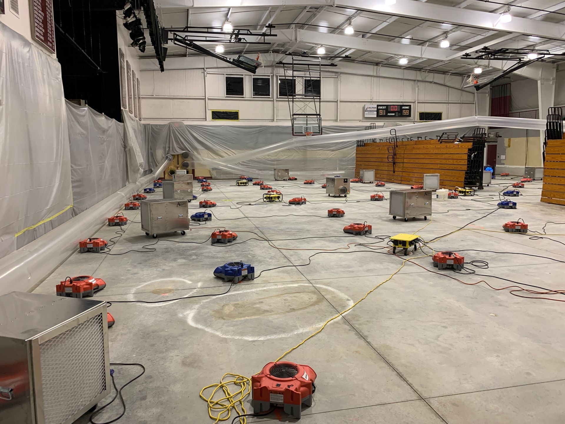 a man is using a vacuum cleaner to clean a flooded floor in a living room .