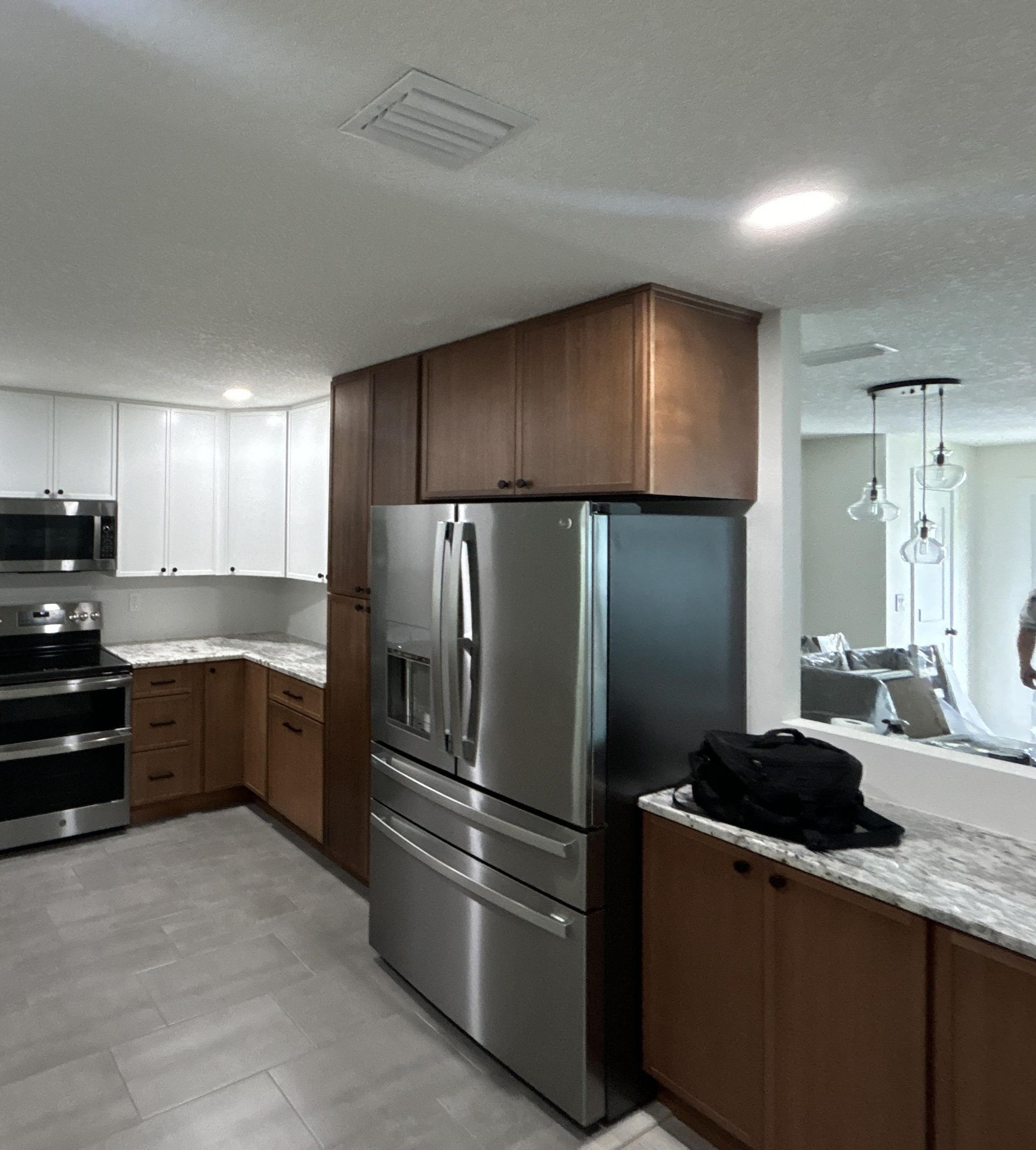 a man is using a vacuum cleaner to clean a flooded floor in a living room .