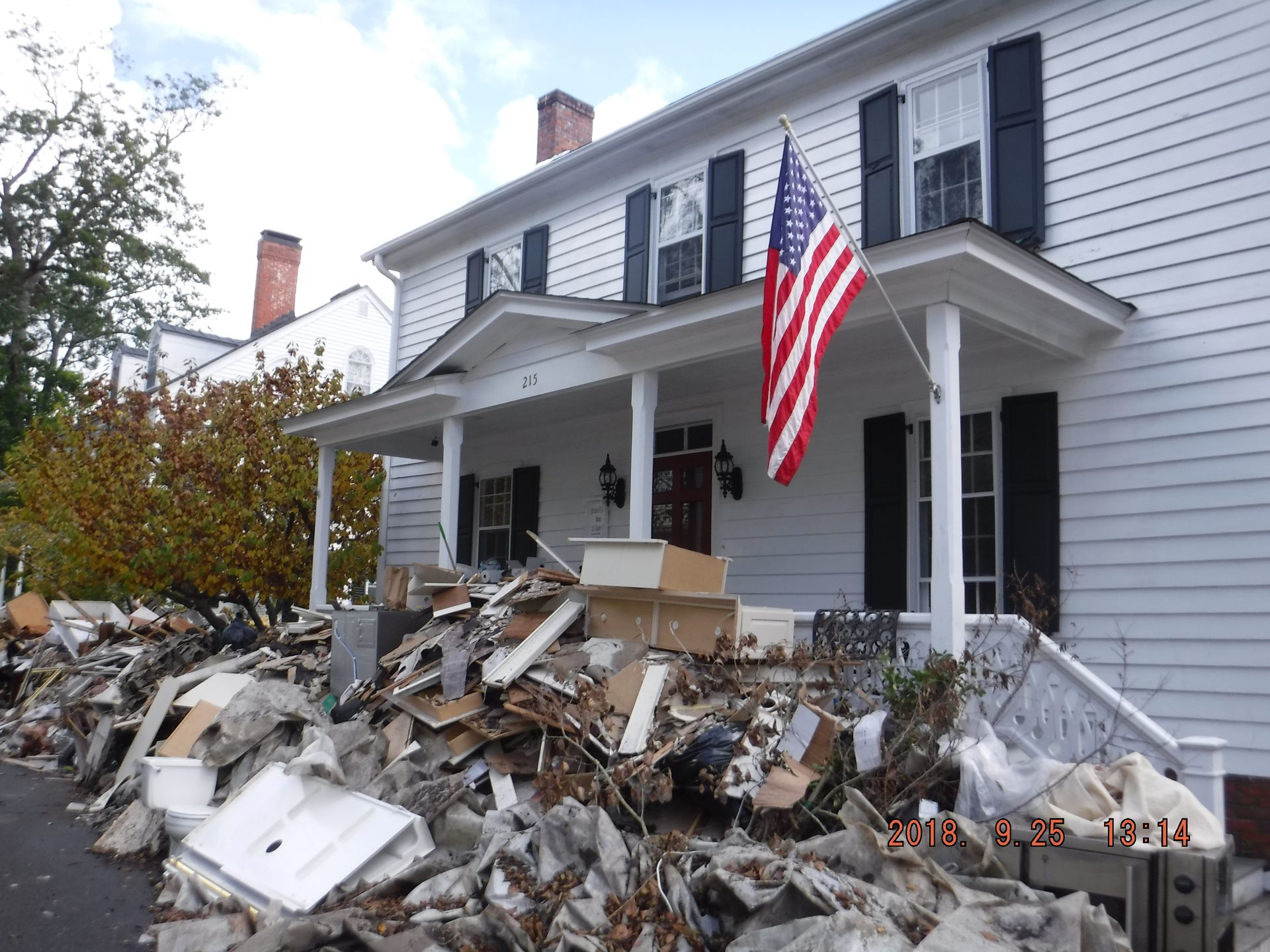 a man is using a vacuum cleaner to clean a flooded floor in a living room .