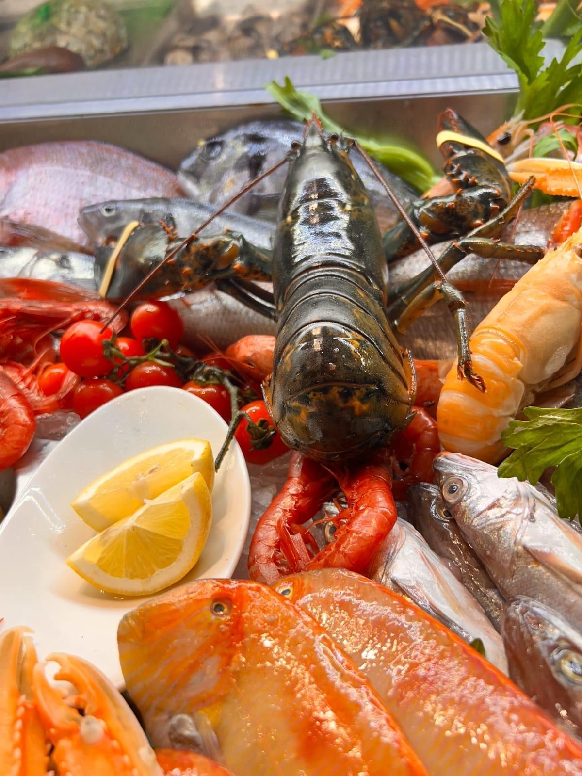 Un'aragosta è appoggiata su un piatto di frutti di mare.