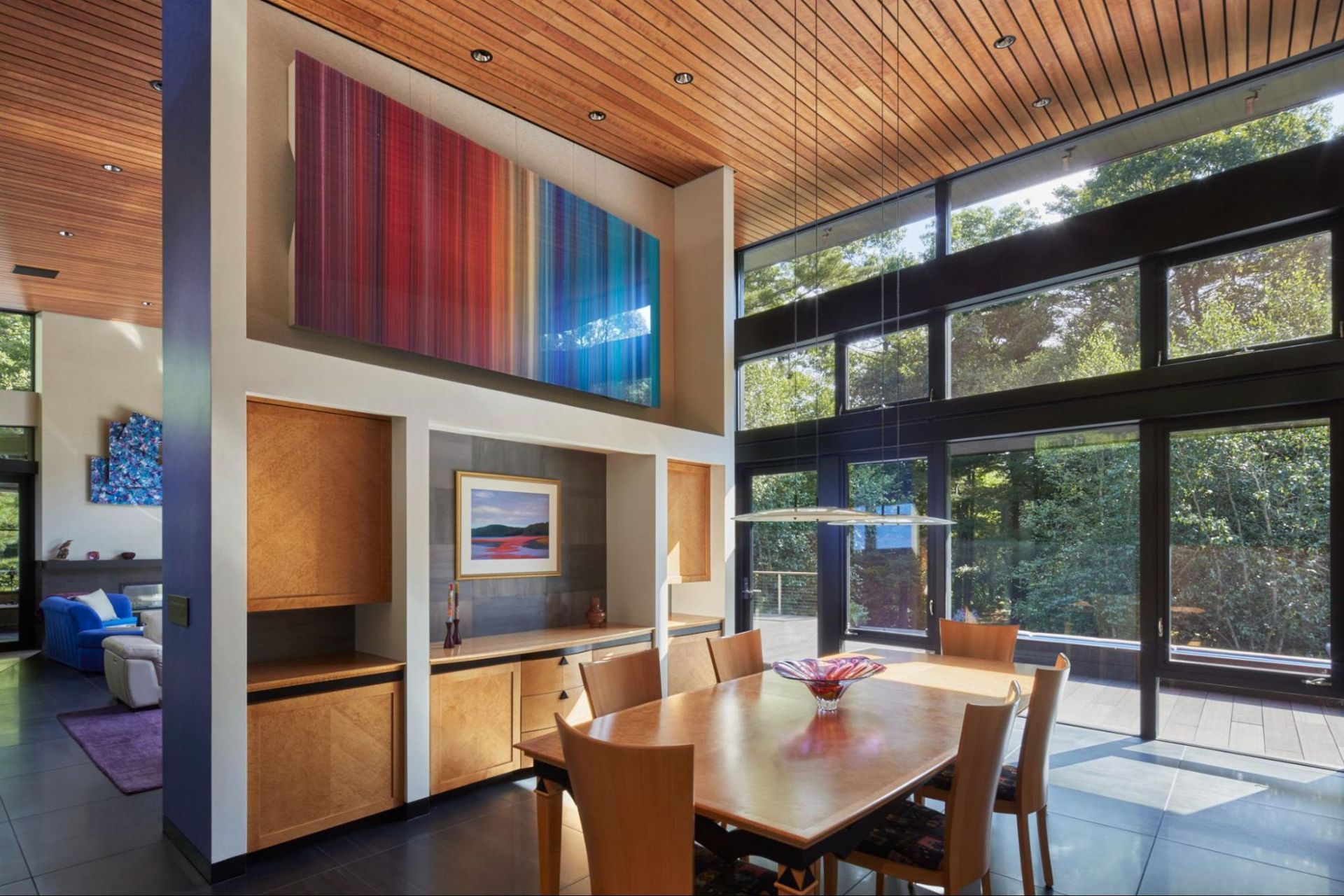 An open dining room with built-in cabinetry, wood ceiling, and glass doors