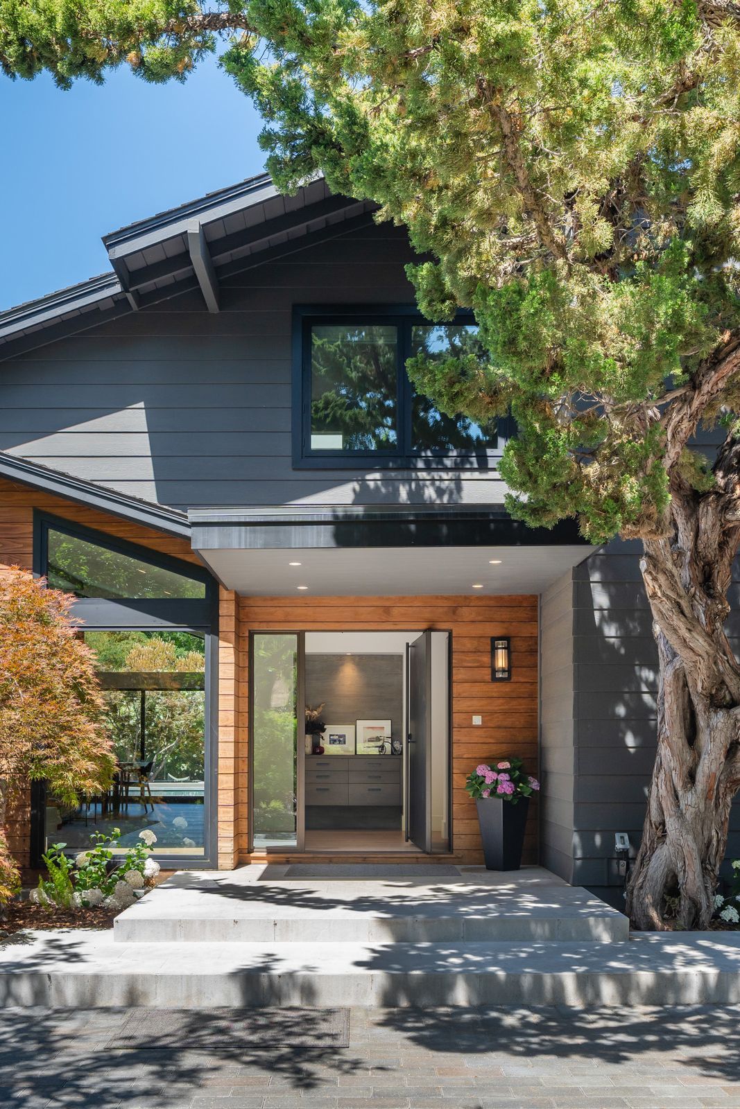 A wide pivot door and sidelight welcome at the entry 