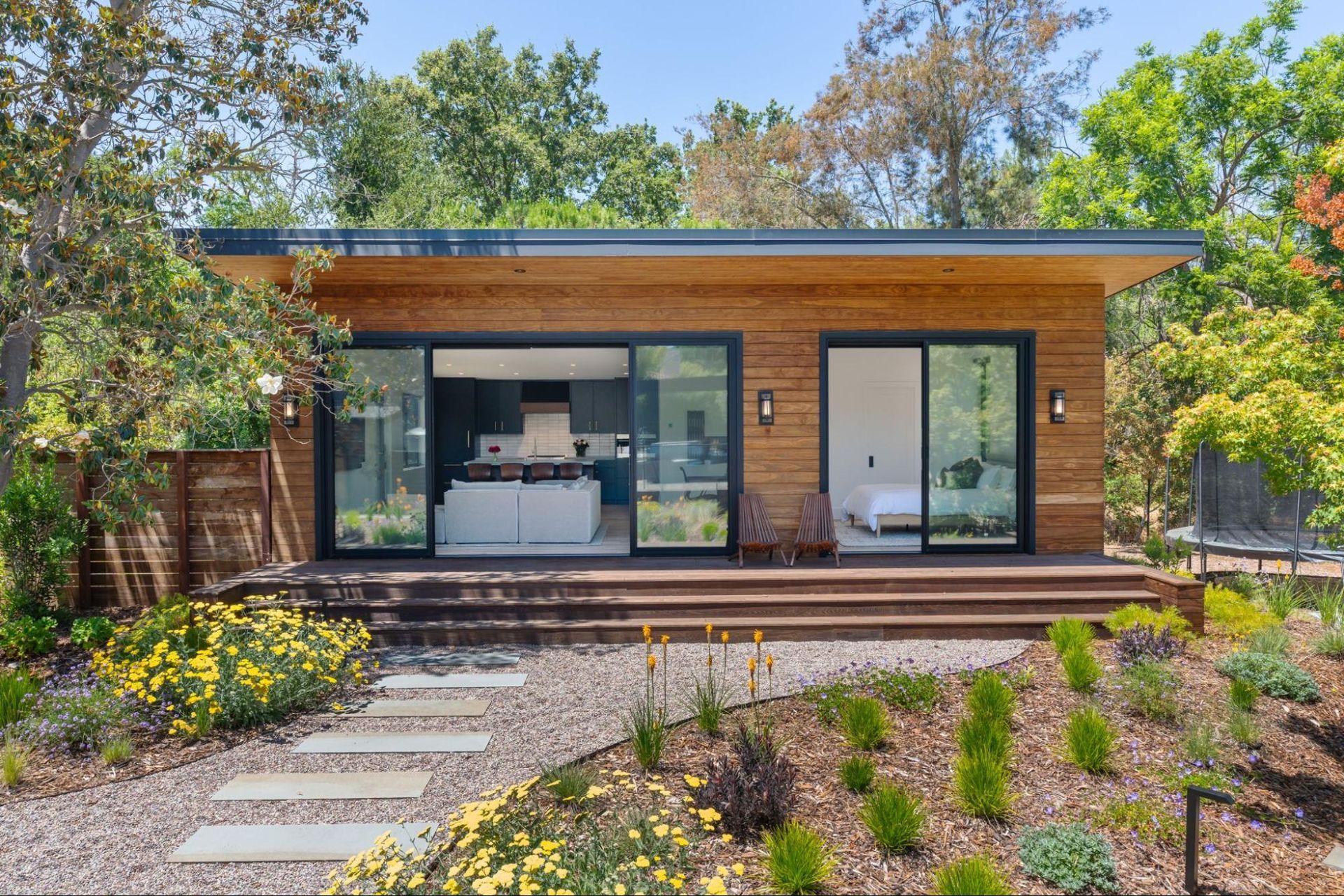 New accessory dwelling unit is surrounded by trees and flowers.