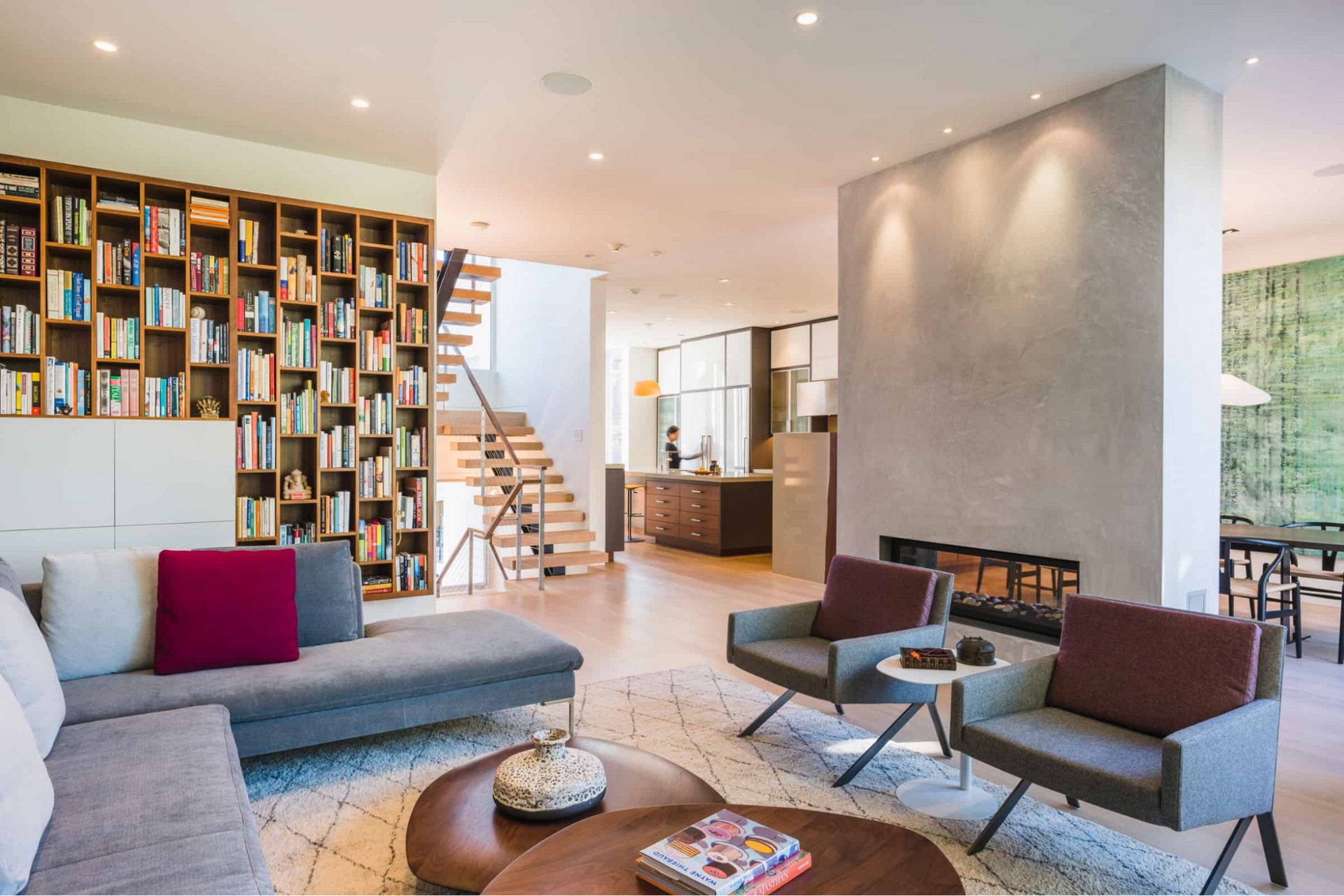 Modern townhouse interior with two-sided fireplace and floating stairs