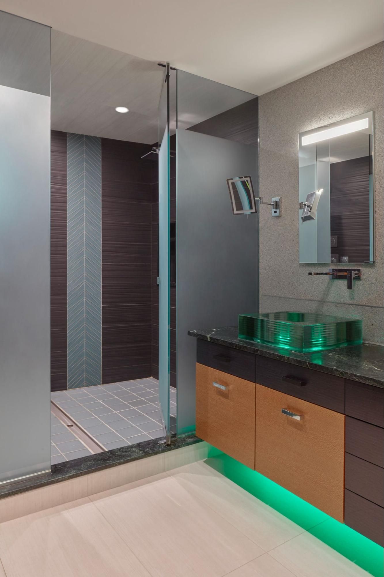 A bathroom with illuminated glass sink and under-vanity lighting