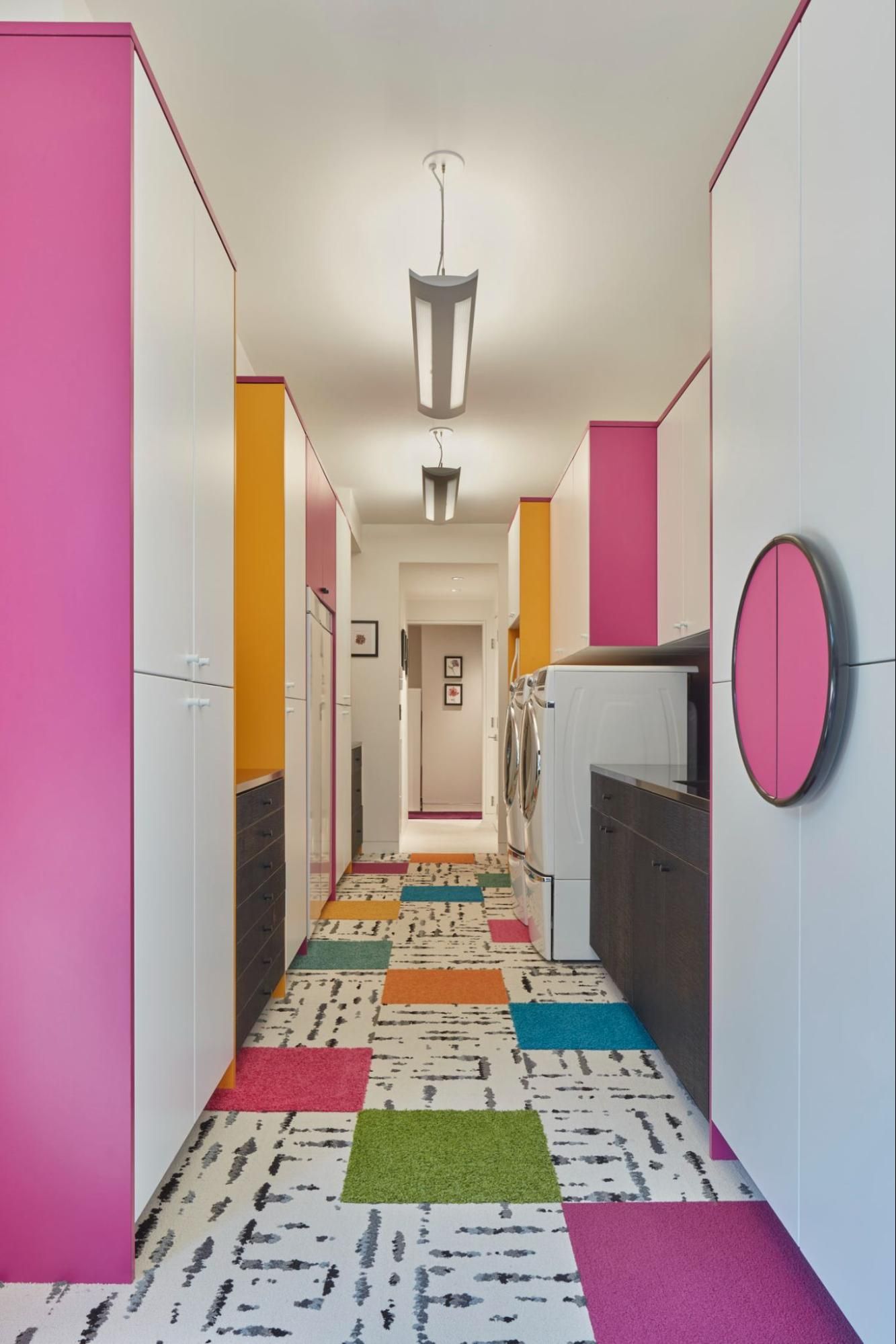 A laundry room with colorful cabinetry and rug