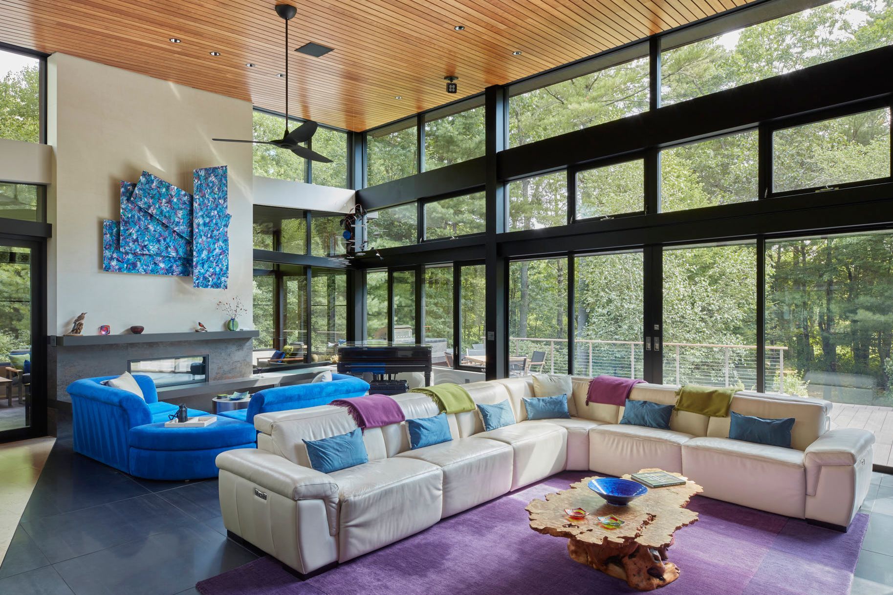 A living room with a lot of windows and a two-sided fireplace