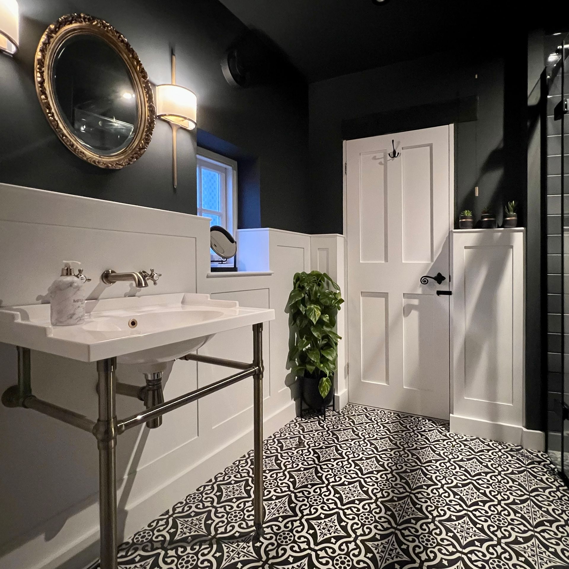 Bathroom design and build in Wiltshire with black and white floor tiles and classic wood panelling on walls