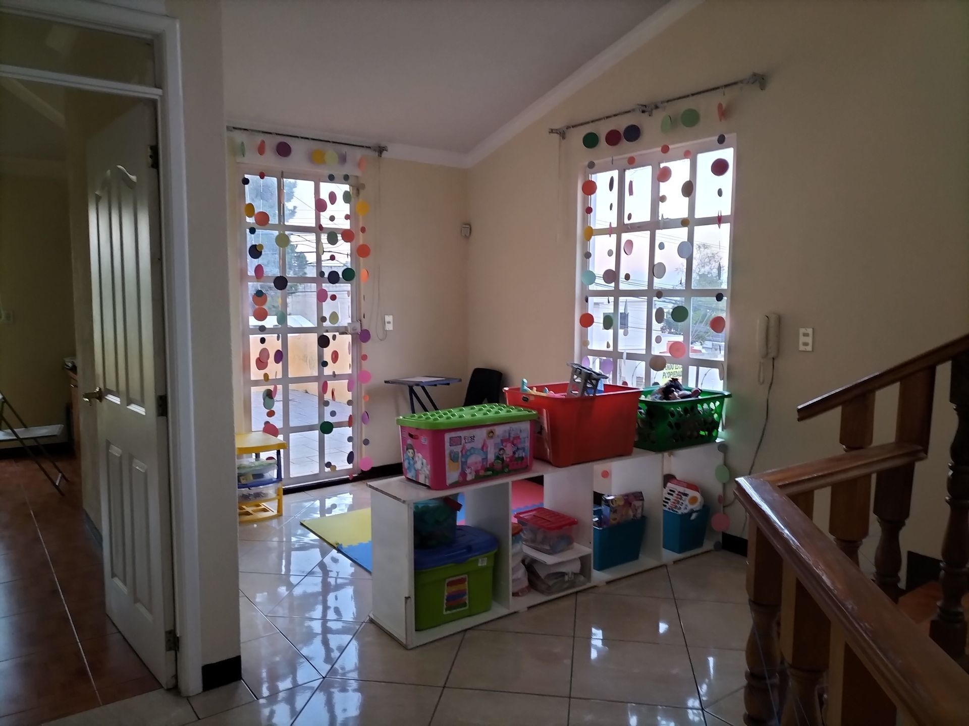 Una habitación con una escalera y un estante con juguetes encima.