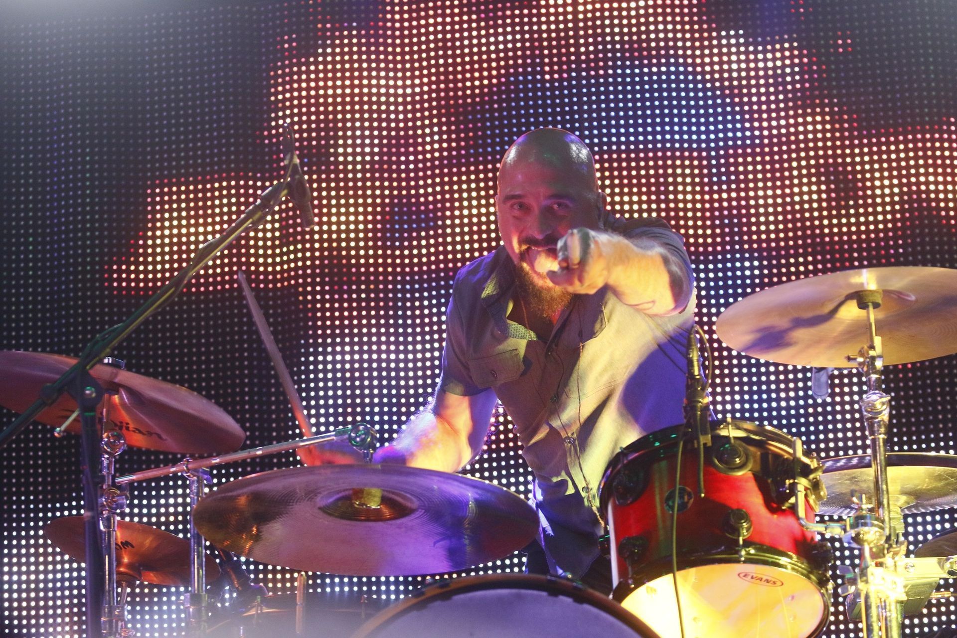 A man playing drums in front of a large screen