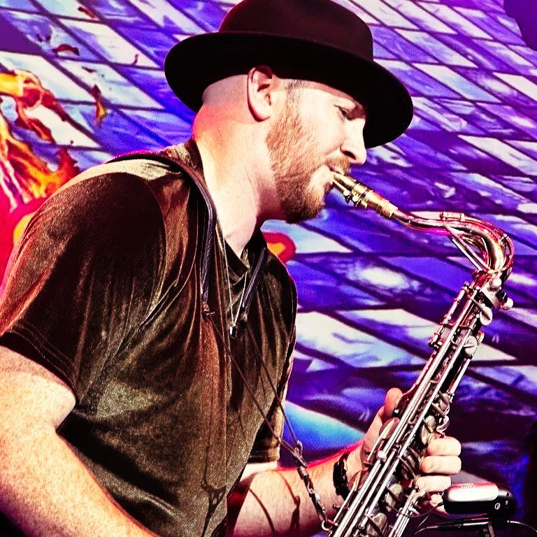 A man in a hat is playing a saxophone
