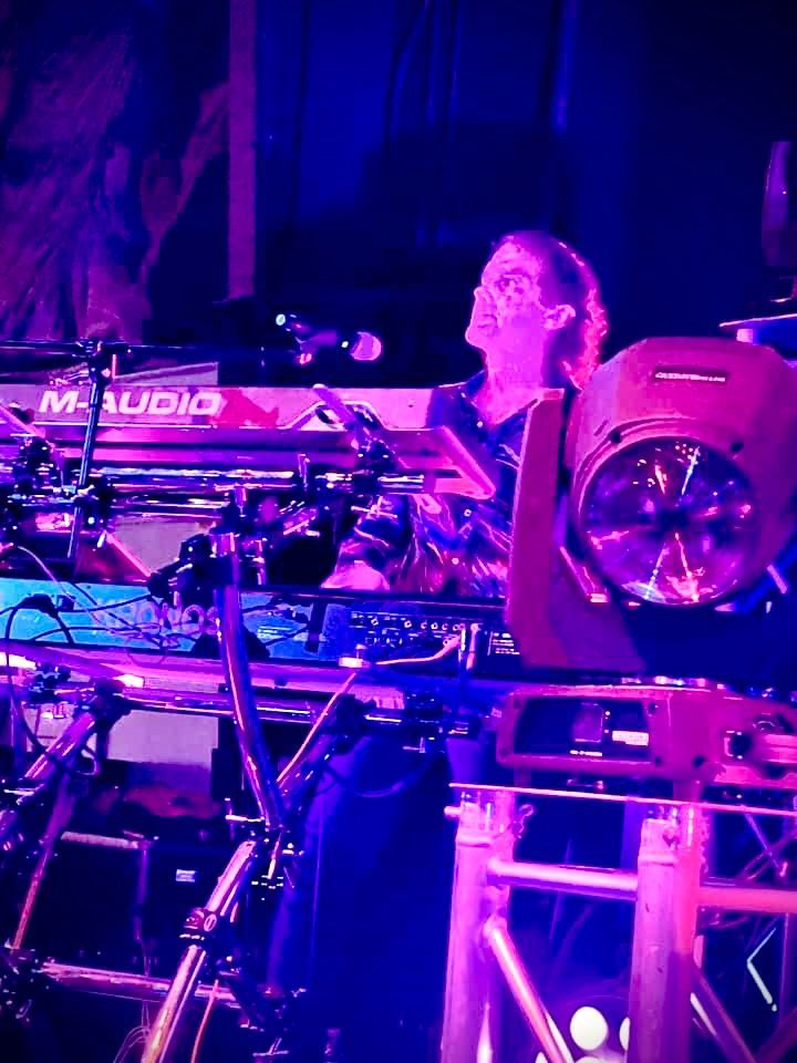 A man is playing drums in front of a m audio keyboard