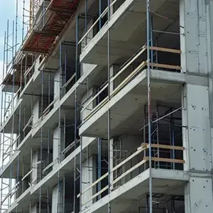 Bright kitchen under renovation with ladder, cabinets, and a person working near the back wall