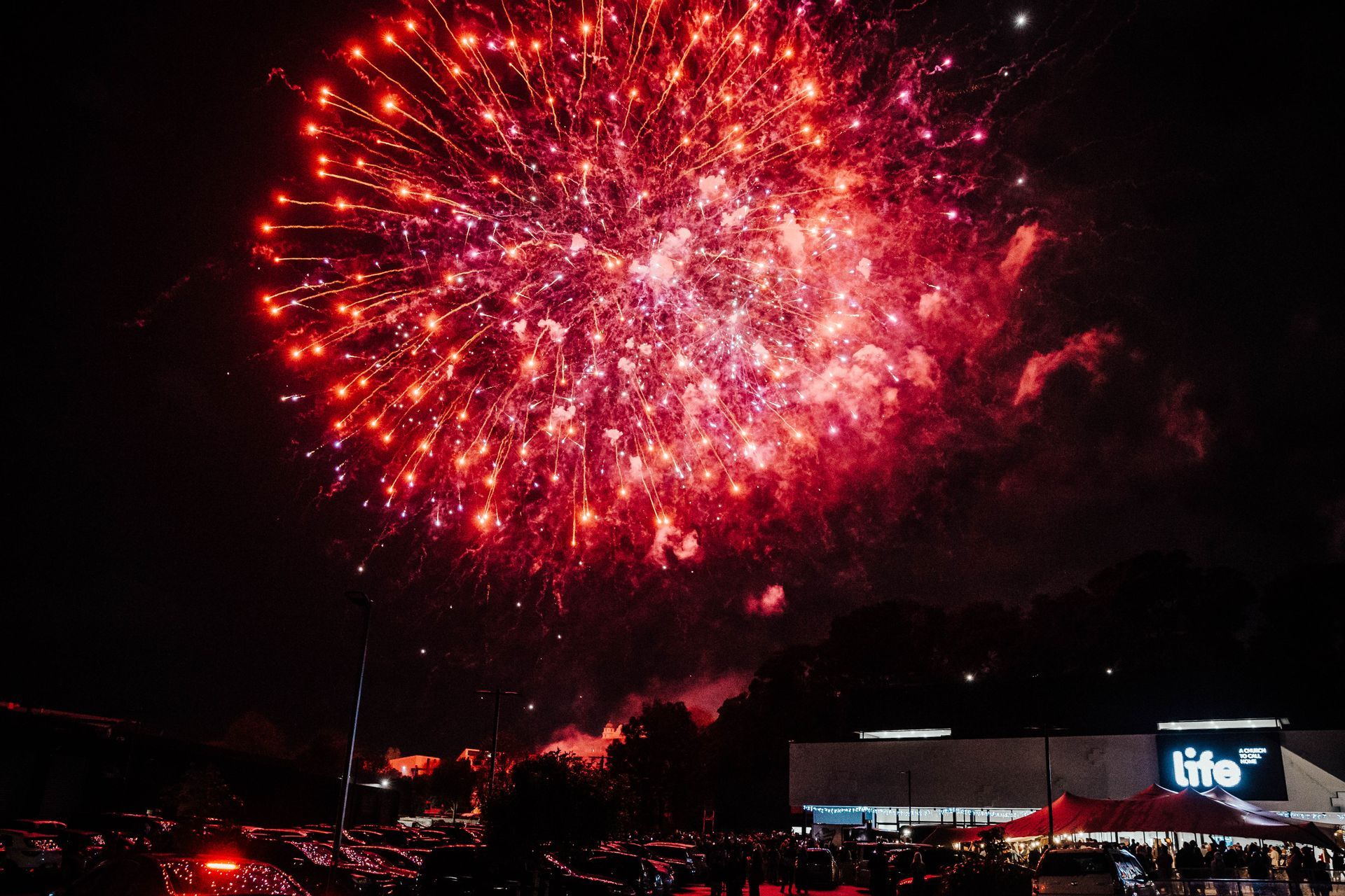 A fireworks display is taking place in front of a life store.