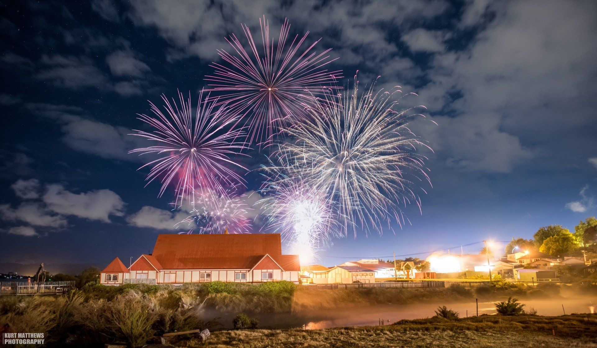 There is a fireworks display in the sky over a building Rotorua NYE