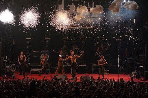 A group of people on a stage with fireworks in the background