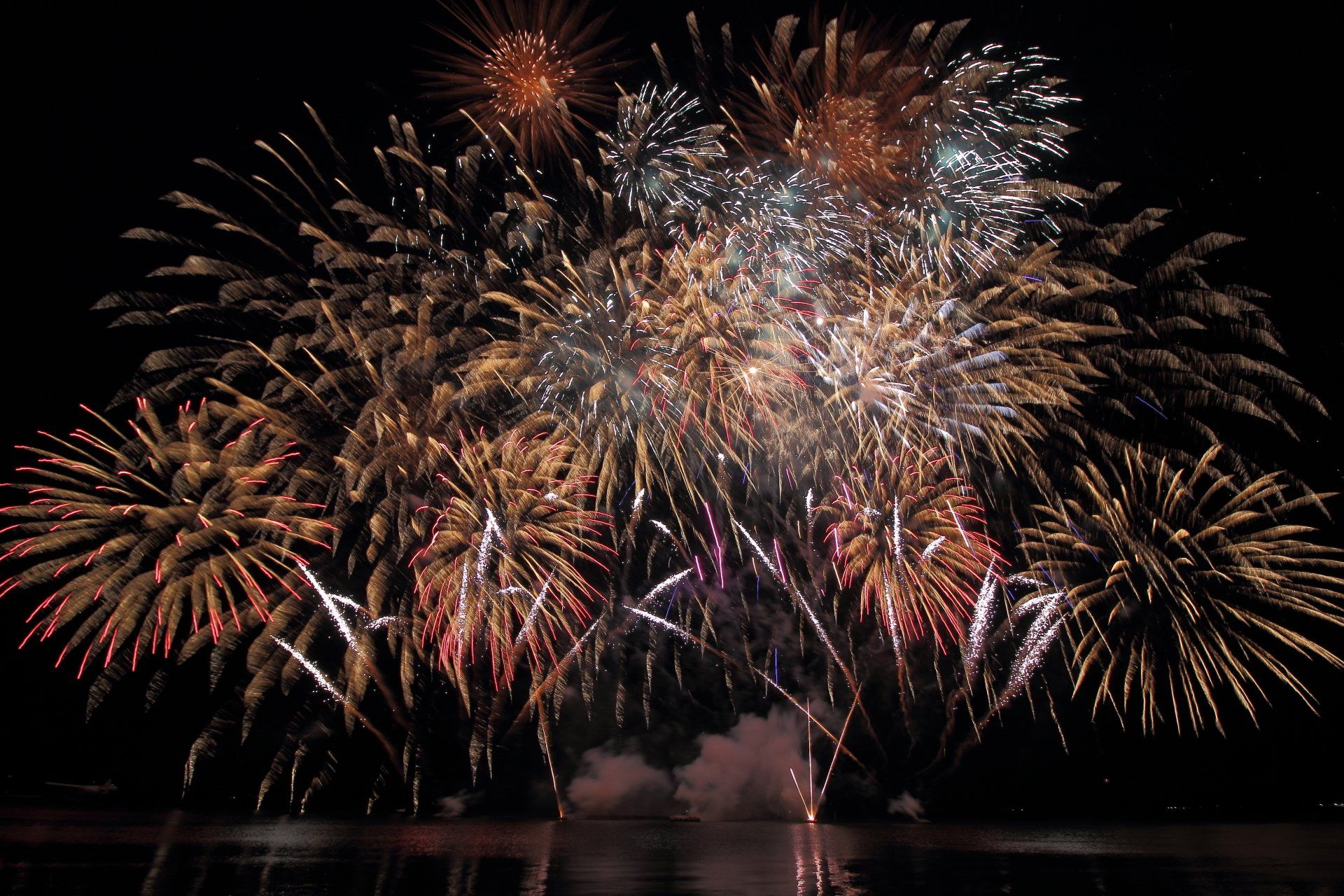 A bunch of fireworks are going off in the night sky