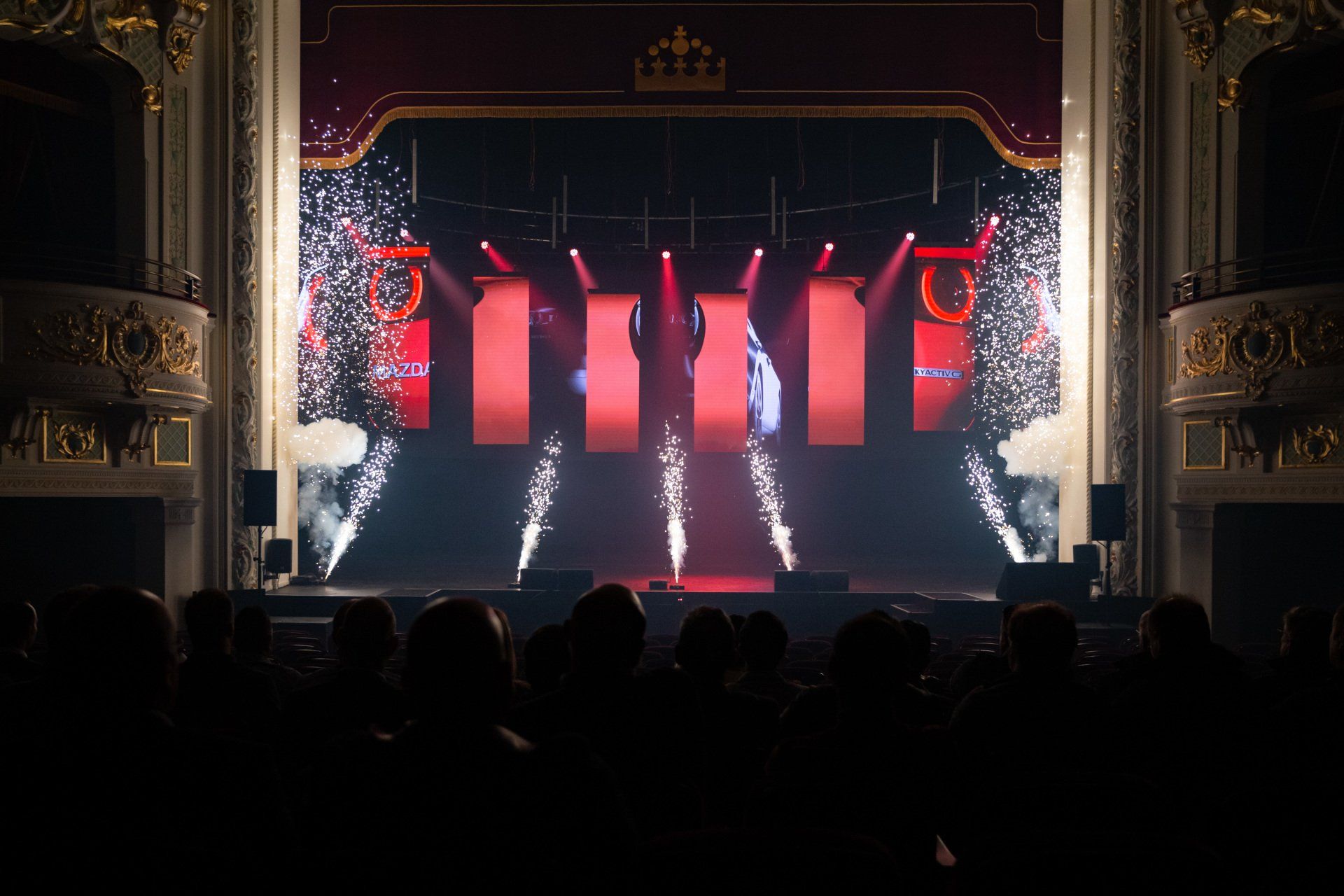 A crowd of people are watching a concert in a theater.