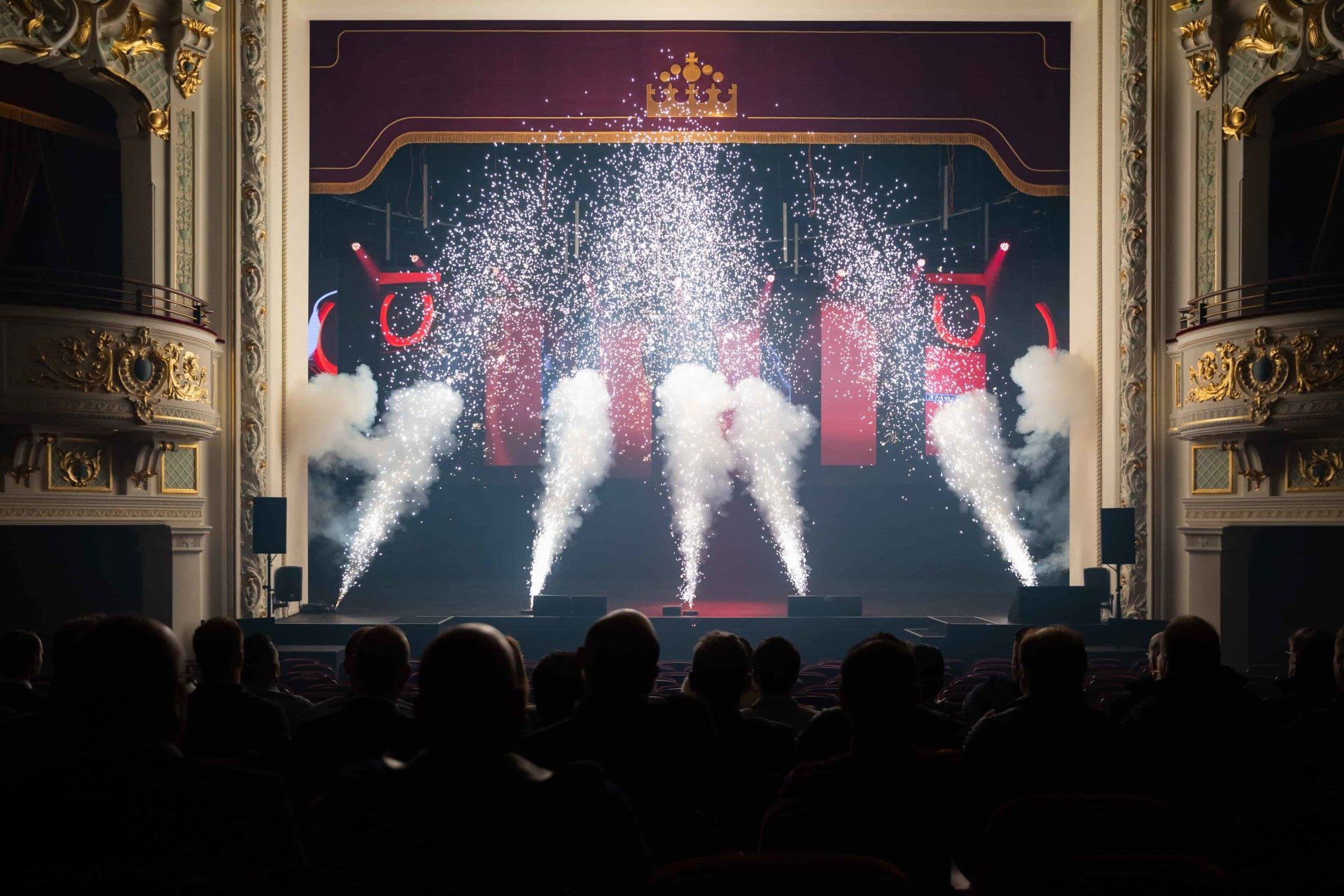 A crowd of people are watching a fireworks display in a theater.