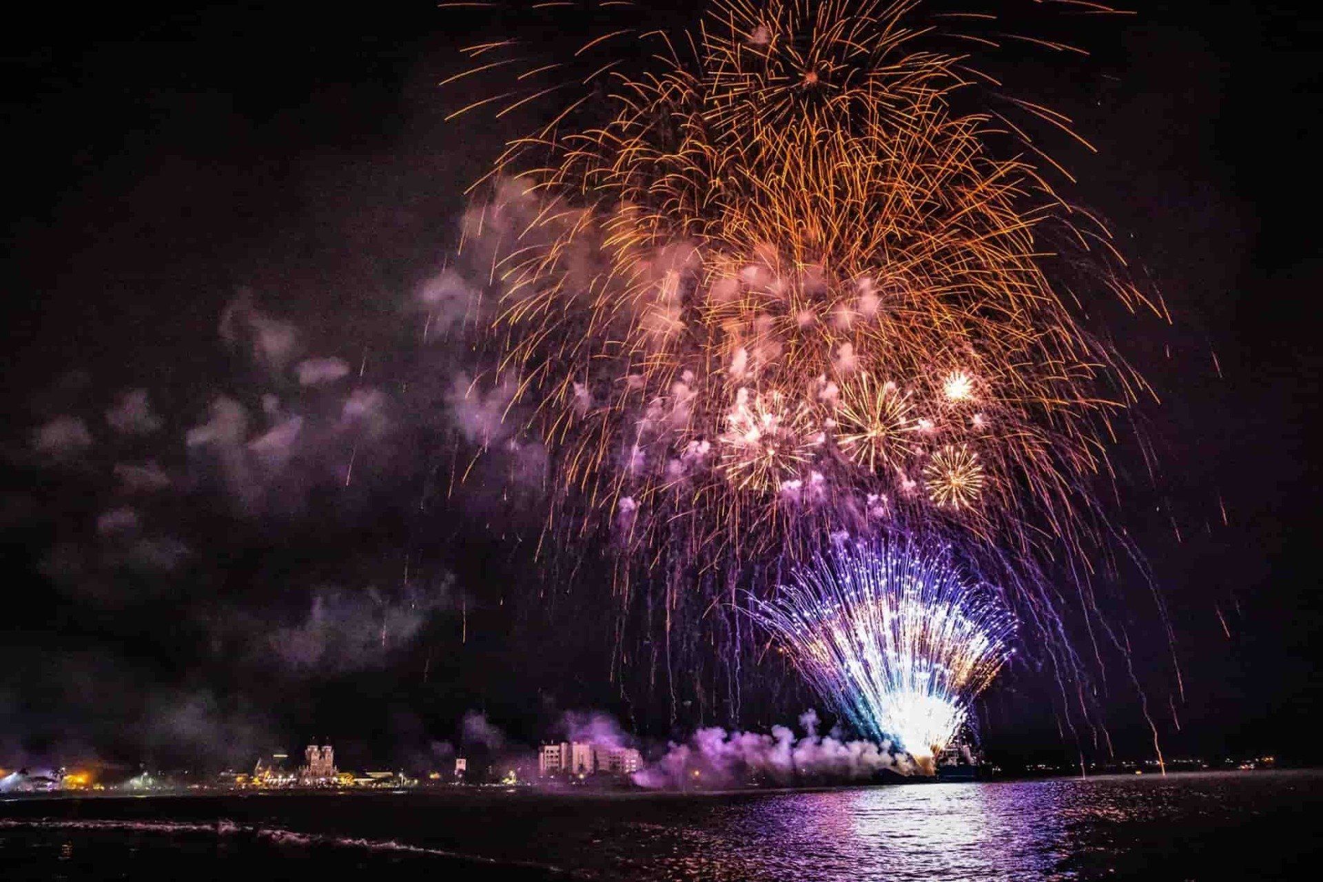 A fireworks display over a body of water at night on the Samoan Harbour in Apia