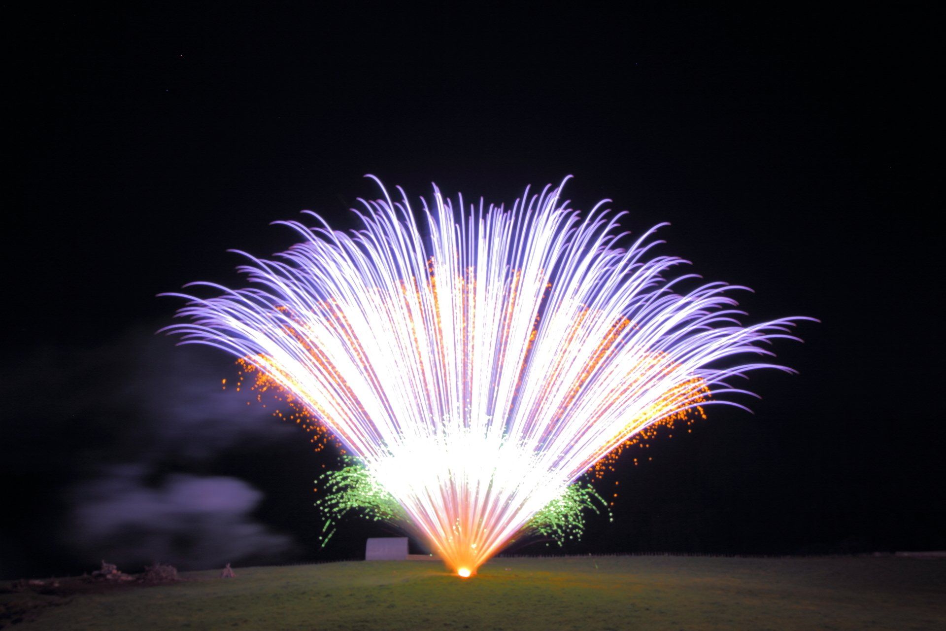 A large fireworks display is going off in the night sky.