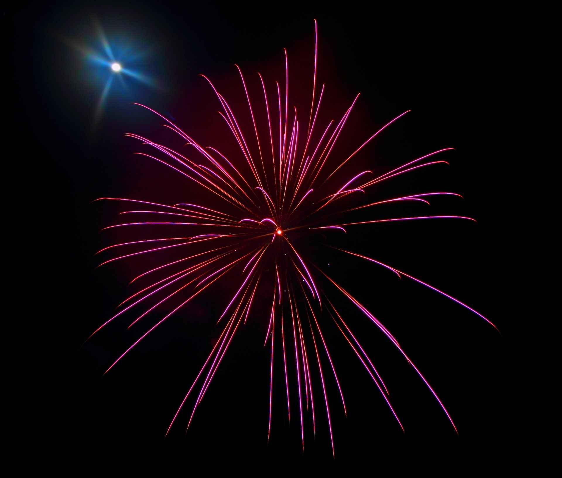A fireworks display with a blue star in the background
