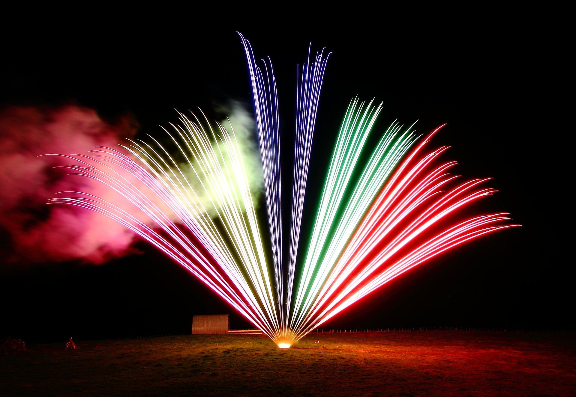 A fireworks display with red white and green fireworks