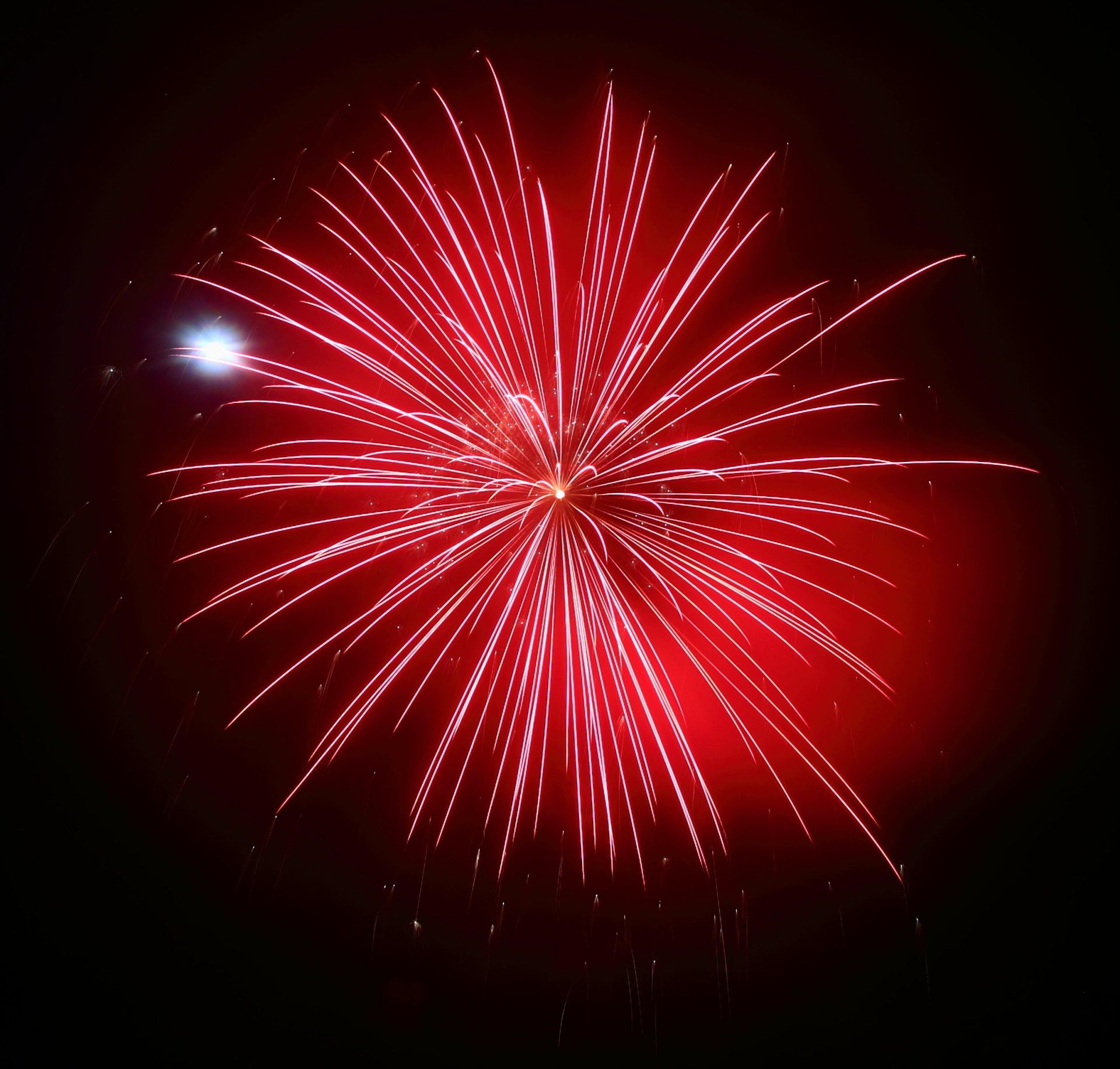 A red fireworks display in the night sky