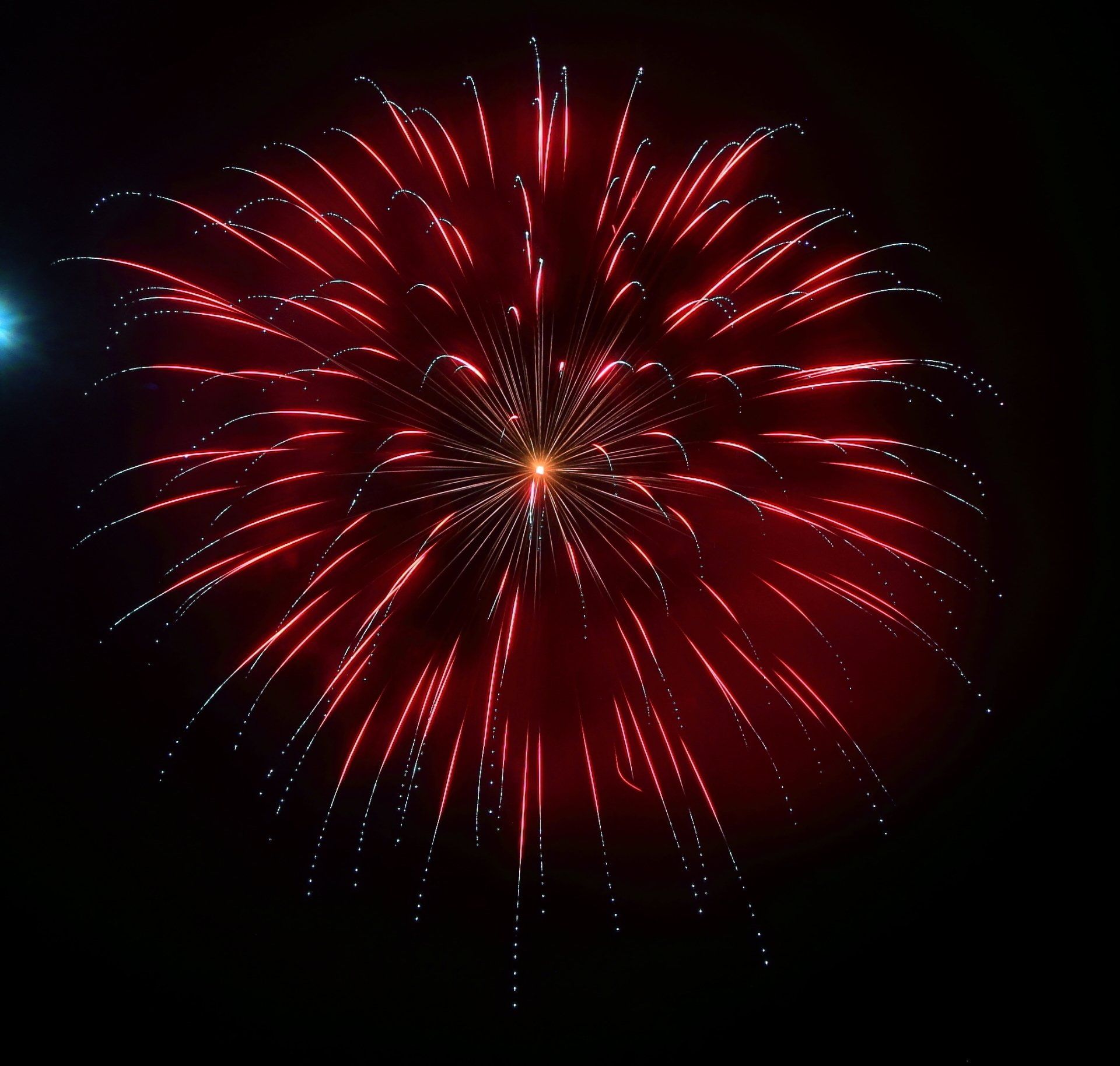 A red fireworks display in the night sky