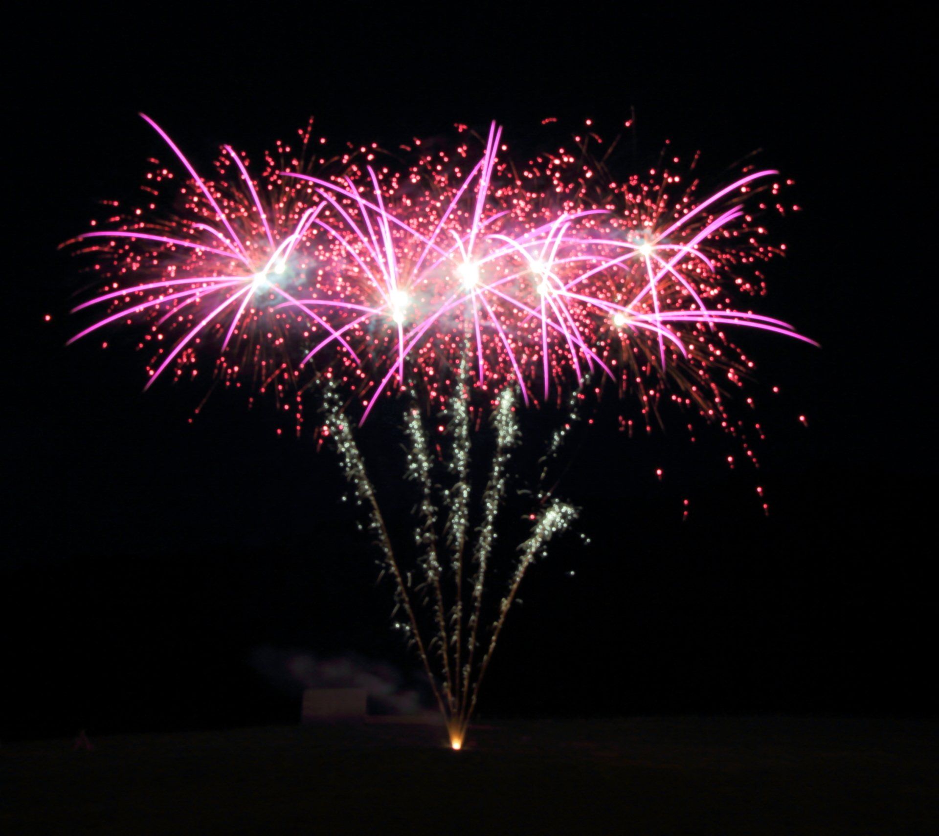 A bunch of fireworks are going off in the night sky