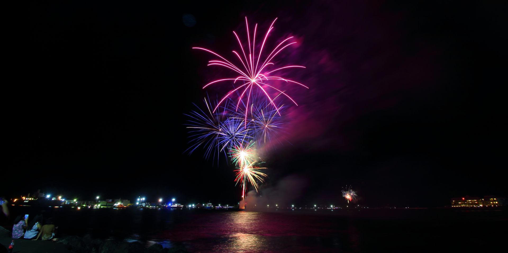A fireworks display over a body of water at night. in Auckland 