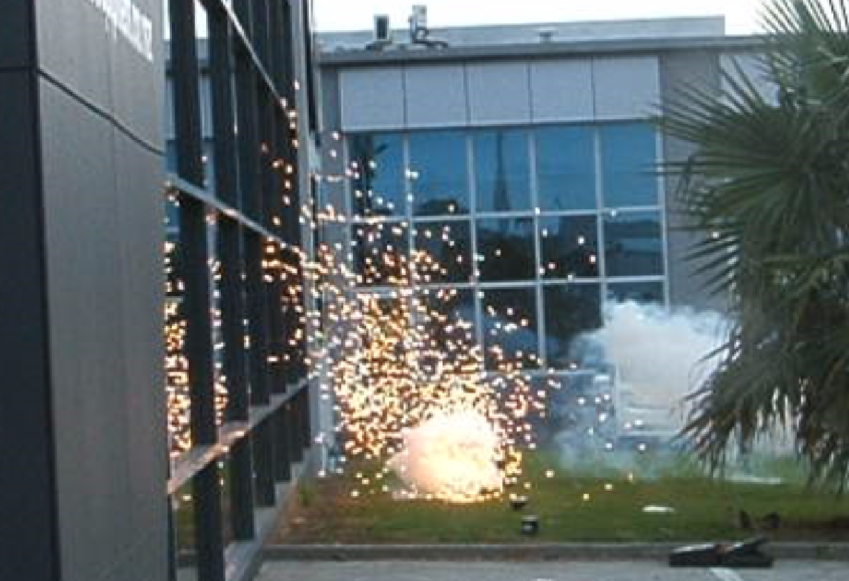 A fireworks display is going off in front of a building