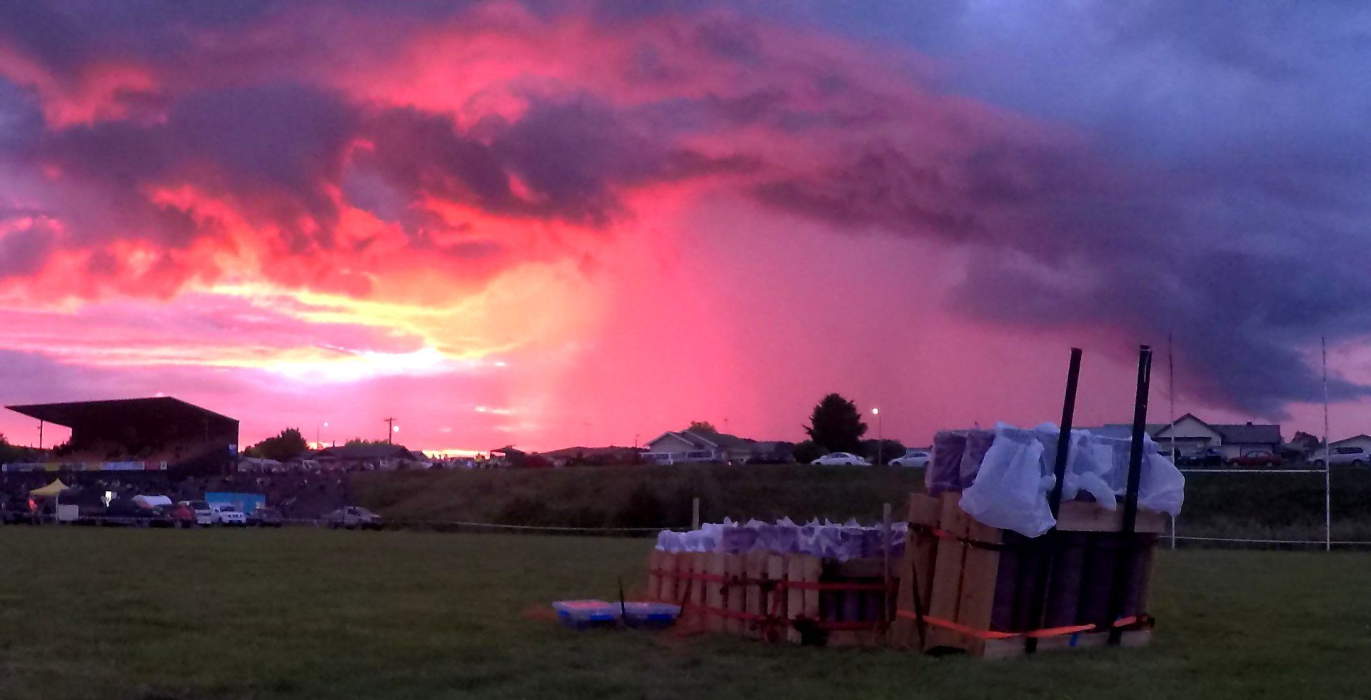 A sunset over a field with a bunch of Fireworks in the field 