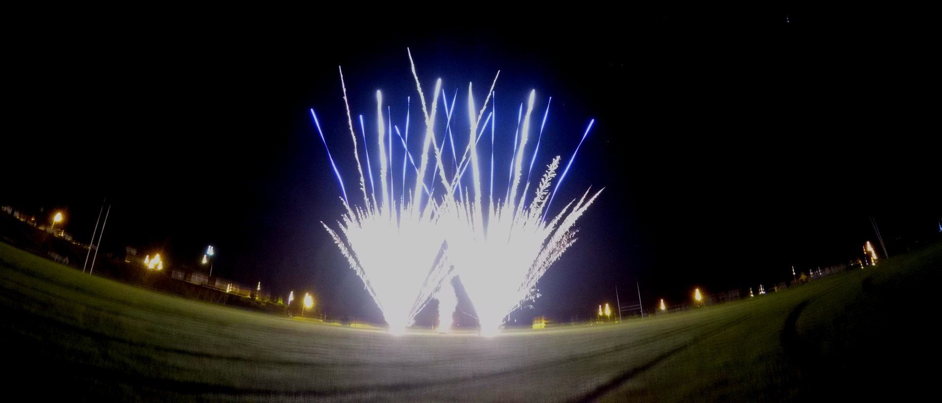 A fireworks display is going off in the night sky.