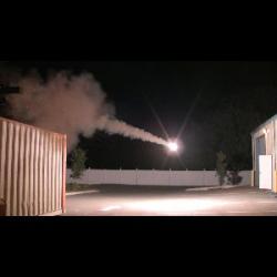 A fireworks display is taking place in a parking lot at night.